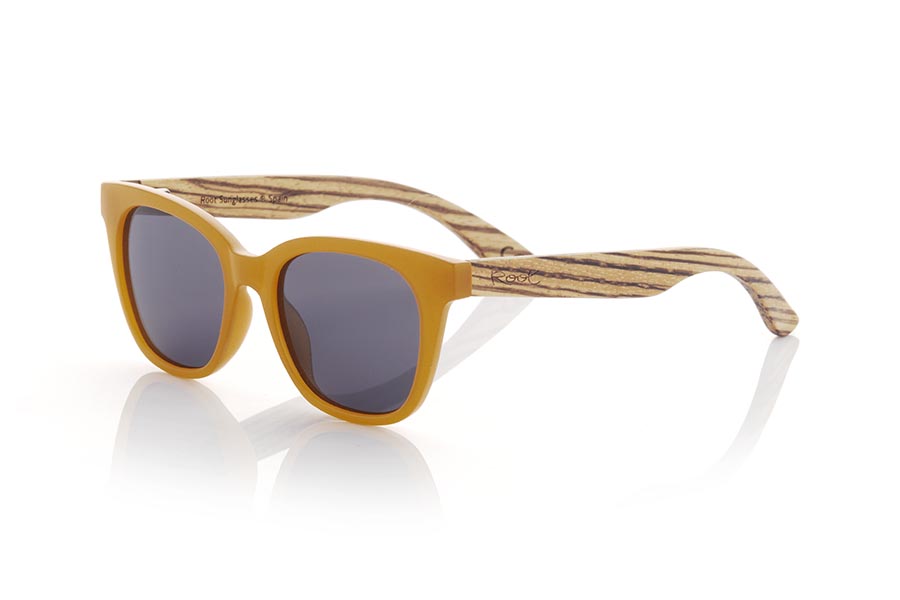 Wood eyewear of Walnut NORA. NORA sunglasses combine a frame in an attractive satin orange tone with walnut wood temples to offer a fresh and natural design. This model with its rounded shapes and ideal size has a slight retro touch and is perfect for women, although it can also look good on daring men. Gradient brown or gray-toned lenses add an elegant touch to these wooden sunglasses. Enjoy a unique style and the protection you need anywhere with the NORA sunglasses from Root. Front Measurement: 143x50mm Caliber: 49 for Wholesale & Retail | Root Sunglasses® 